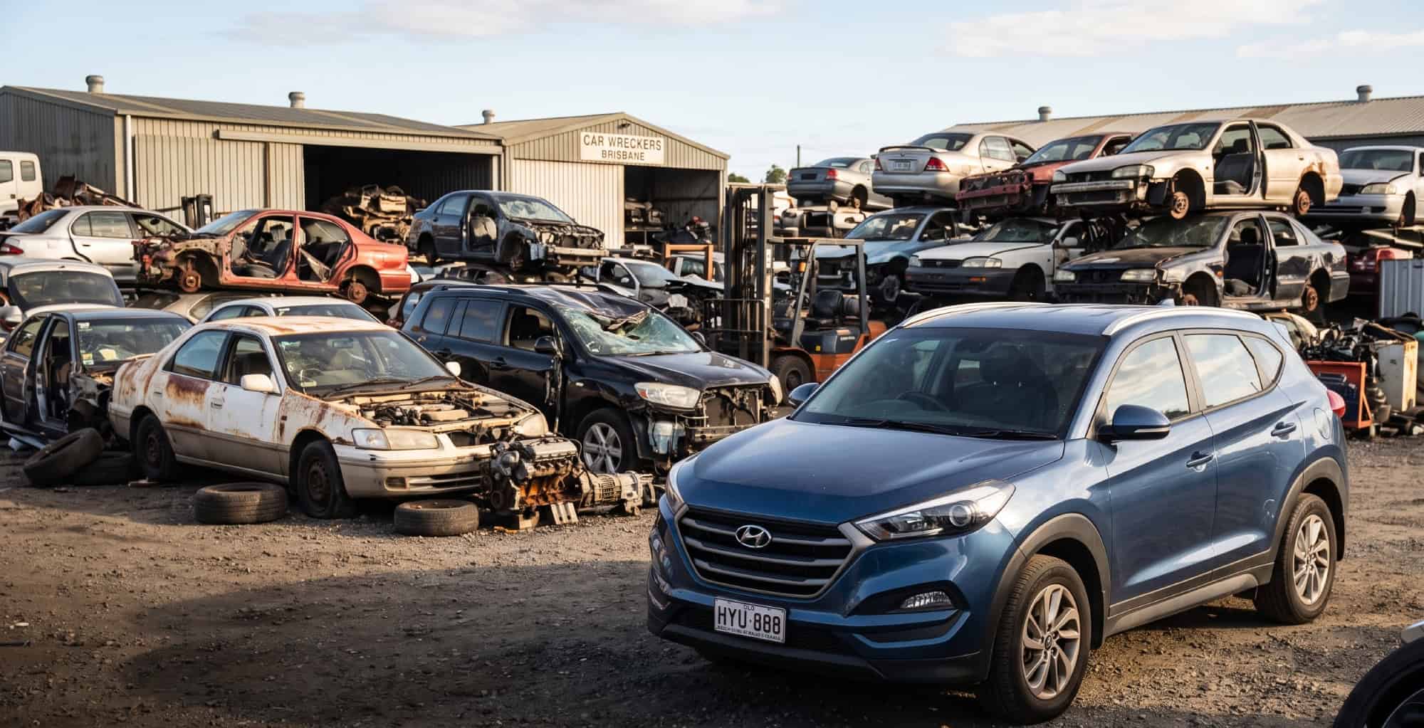 Mechanic inspecting a recycled Hyundai at a Brisbane wrecking yard