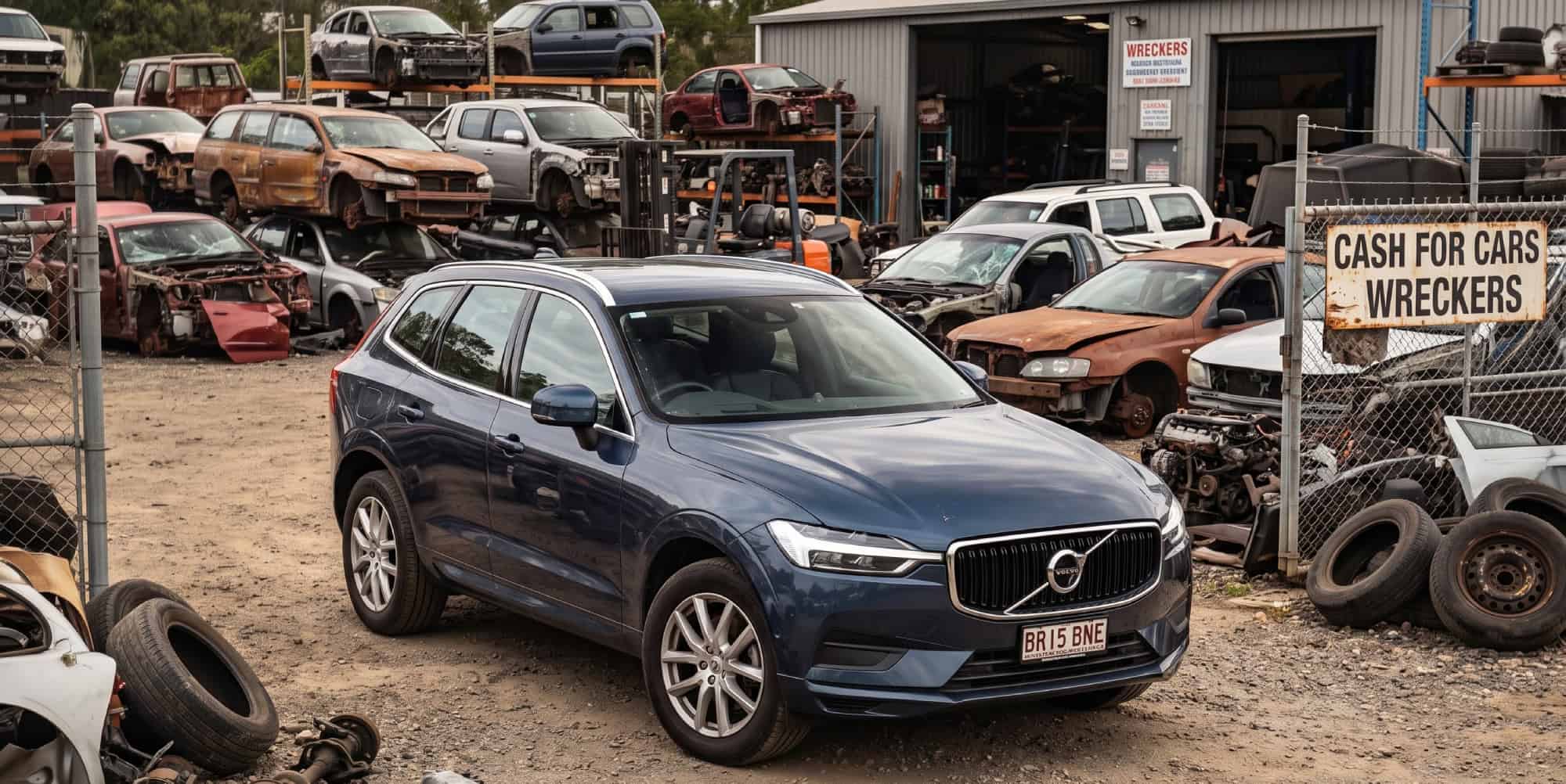Mechanic inspecting a recycled Volvo at a Brisbane wrecking yard